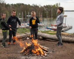 Przytulne miejsce na ognisko w ośrodku Róża Wiatrów, otoczone naturą, idealne do wieczornych spotkań nad jeziorem Święcajty Miejsce na ognisko w ośrodku Róża Wiatrów w Węgorzewie, nad jeziorem Święcajty