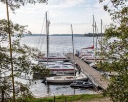 Żaglówki na jeziorze Święcajty widziane z plaży ośrodka Róża Wiatrów – idealne miejsce na wypoczynek nad wodą Widok na jezioro Święcajty i żaglówki z plaży ośrodka Róża Wiatrów w Węgorzewie